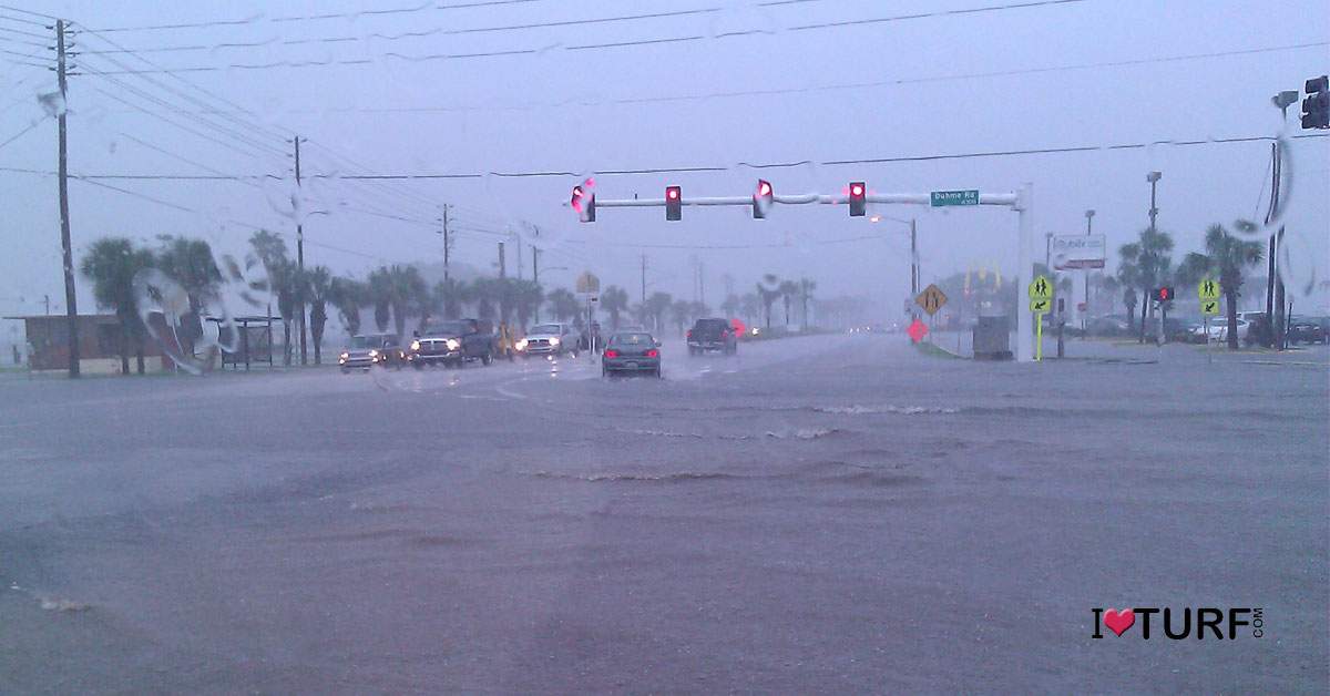 Street flooded from heavy rains with cars moving through the flood waters